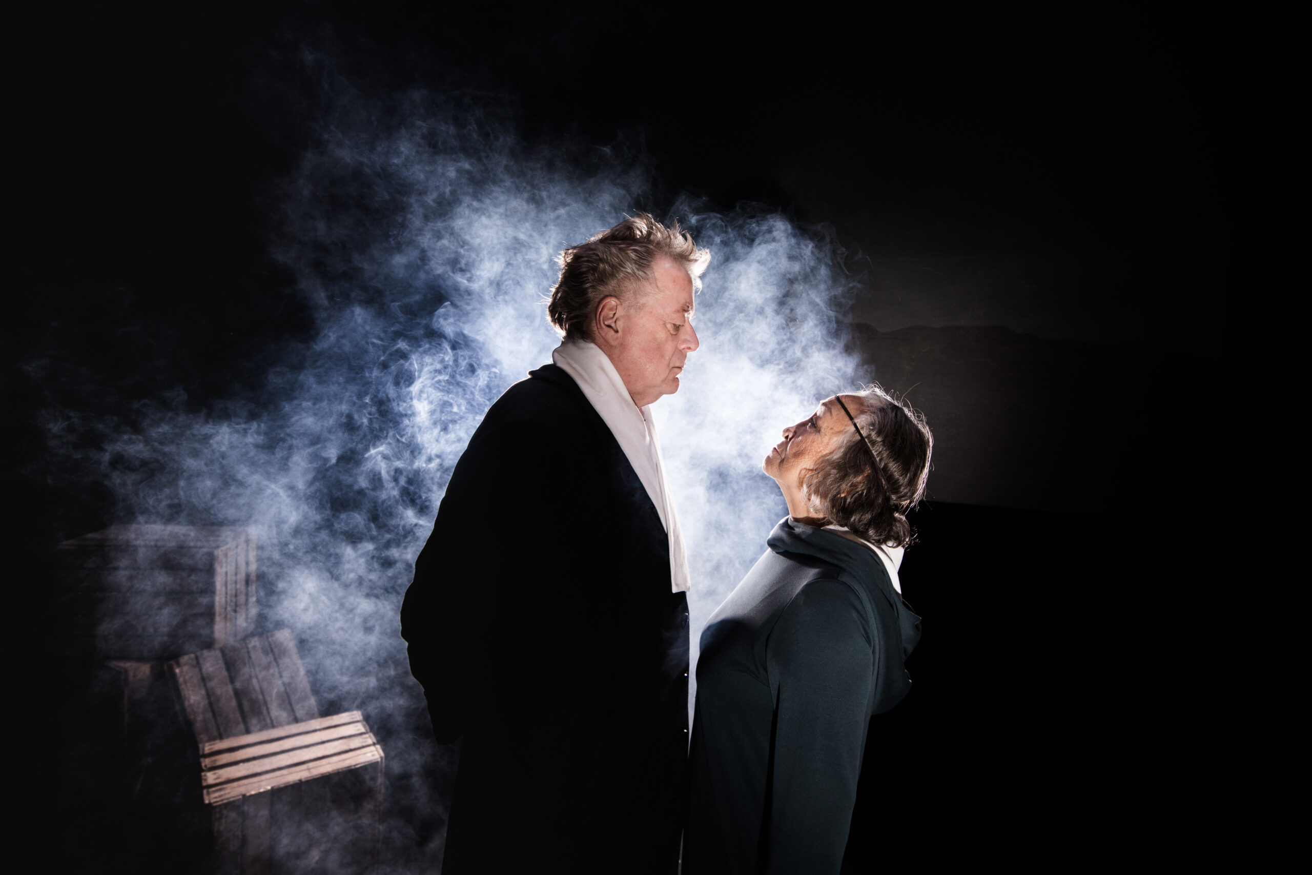 En mand og en kvinde står, og kigger op på hinanden med røg omkring dem.